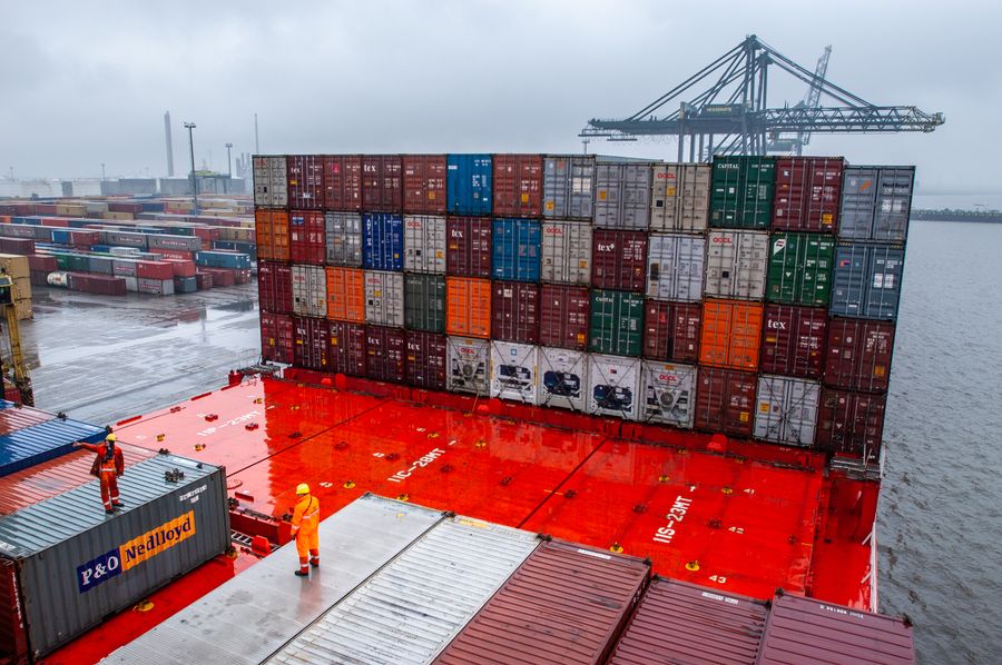 Dock workers preparing shipping containers for loading at a port