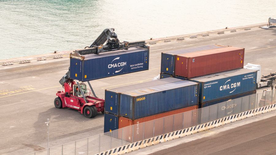 Forklift handling shipping containers at a port terminal